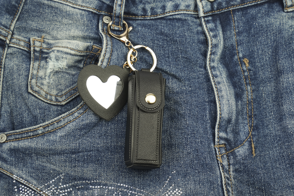 Fashionable lipstick and pocket atomizer bag with snap fastener, small heart-shaped mirror, and keychain snap hook, black