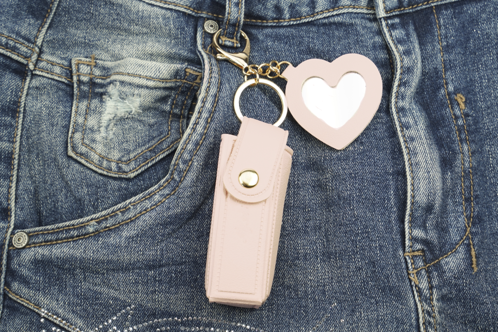 Fashionable lipstick and pocket atomizer bag with snap fastener, small heart-shaped mirror, and keychain snap hook, pink